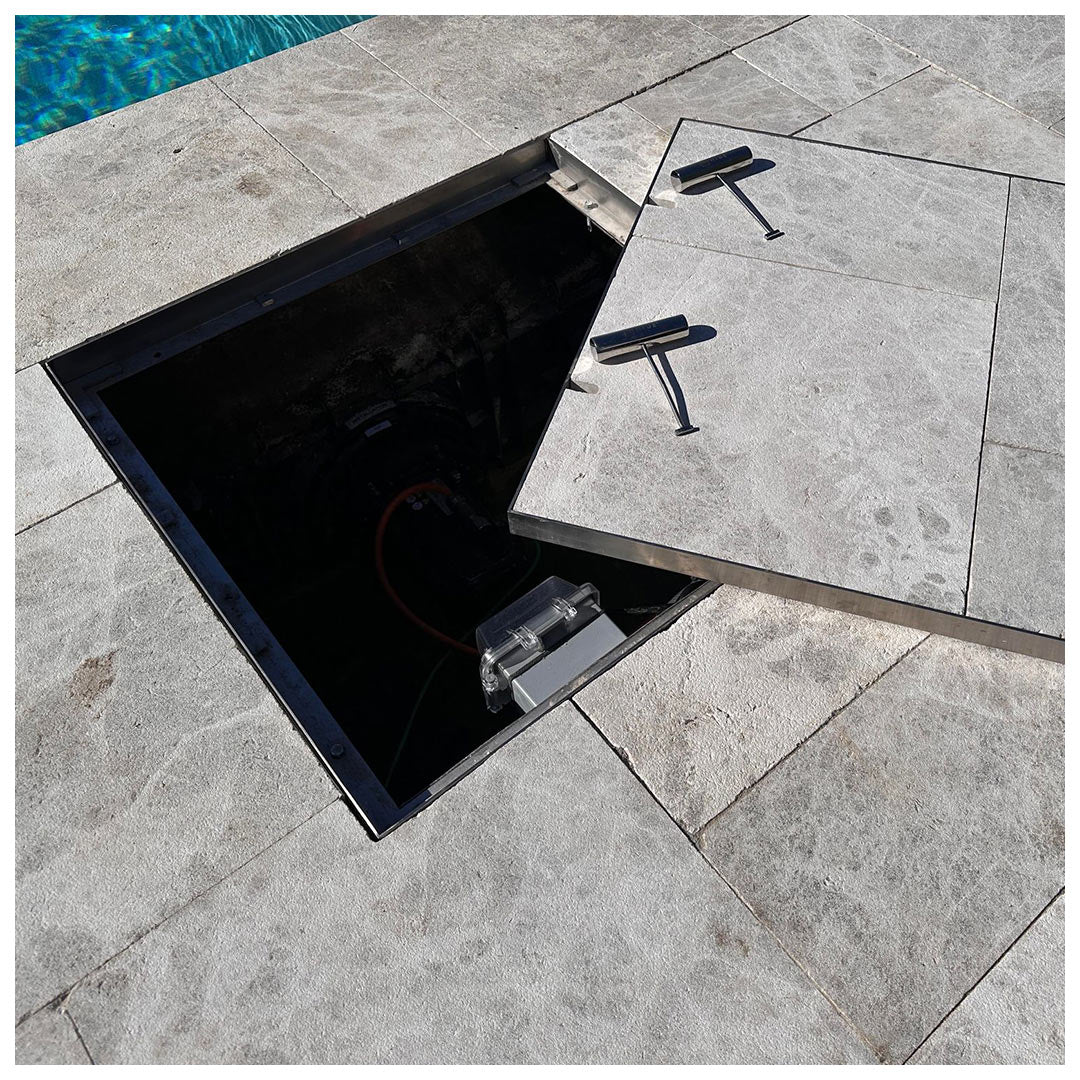 Large HIDE 656mm Manhole Access Cover with grey tile inlay. Covering a swimjet system, creating a sleek and flawless finish.